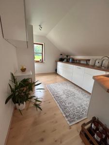 a kitchen with white cabinets and a rug on a wooden floor at WaldGold in Fichtelberg