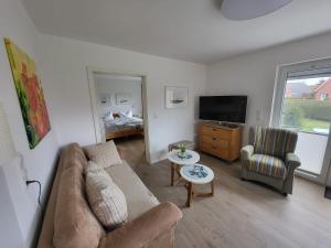 a living room with a couch and a tv at Ferienwohnung Stiena EG in Greetsiel