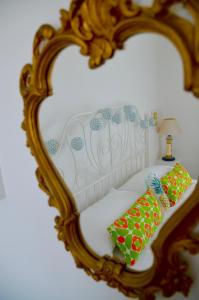 a mirror reflecting a bed with two pillows on it at B&B Il Tentacolo in Ventimiglia