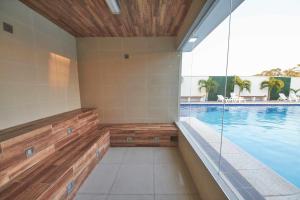 an indoor swimming pool with aitating room with a swimming pool at Nexus SUITE Airport HUB in Vila El Carmen +3 photos