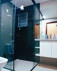 a bathroom with a glass shower with a toilet and a sink at Nexus SUITE Airport HUB in Vila El Carmen