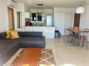 a living room with a couch and a table and a kitchen at Residence port la galere in Théoule-sur-Mer