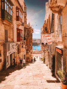 un grupo de personas caminando por una calle en Ivory Suite Valletta, en La Valeta