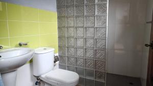 Un baño con inodoro, lavabo y ducha. en Kemmiu room, en São Tomé