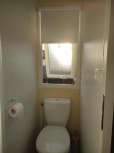 a bathroom with a white toilet and a window at BUNGALOW E10 na lands hause in Pataias +13 photos