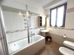 Un baño con bañera, lavabo e inodoro. en casa Angelica Germignaga, en Germignaga 26 fotos más