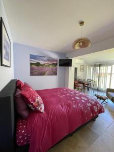 a bedroom with a pink bed and a dining room at Au combe de canet in Anthé +66 photos
