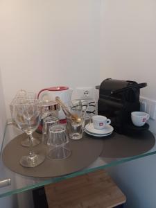 a table with glasses and a coffee maker on it at Relais al Porto Suite ORA in Peschiera del Garda