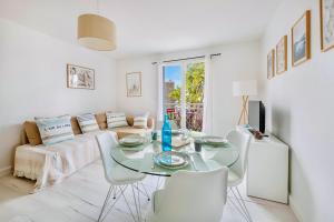 a living room with a table and chairs and a couch at Le Joli Baulois in La Baule