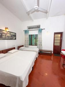 a room with three beds and a window at Fortuna Bungalows in Kandy