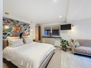 a bedroom with a large white bed and a couch at Le Studio de Lisa in Strasbourg