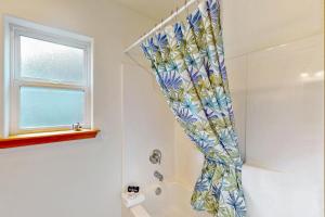 einen Duschvorhang im Bad mit Fenster in der Unterkunft Blue Wave Cottage in Pacific Beach + 13 Fotos