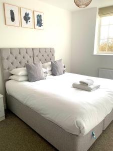 a bedroom with a large bed with white sheets and pillows at West Street Mews - Serviced Accommodation in Exeter