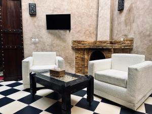 un soggiorno con due sedie e un camino di 66 Dar Aarab - Marrakech a Marrakech