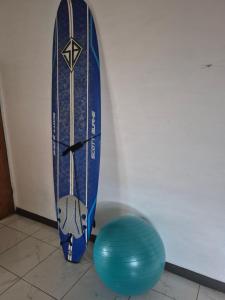 Ein Surfbrett lehnt an einer Wand neben einem blauen Ball in der Unterkunft Tides Lobitos in Lobitos + 13 Fotos