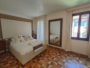 una camera da letto con un letto grande e uno specchio di La Grande Bellezza Deluxe House a Venezia