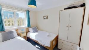 a small bedroom with two beds and a cabinet at F49 Junesta, Riviere Towans in Hayle