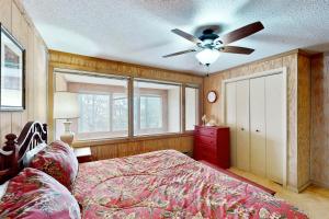 Un dormitorio con una cama y un ventilador de techo. en Skyleaf E-12, en Sugar Mountain