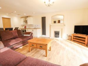 a living room with a couch and a tv and a table at Willow Cottage in Barrow upon Humber