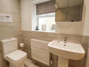 a bathroom with a white sink and a toilet at Willow Cottage in Barrow upon Humber +14 photos