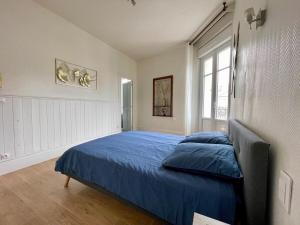a bedroom with a blue bed and a window at Appartement T2 Centre Ville GS2 in Châteauroux