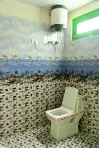 bagno con servizi igienici e un dipinto sul muro di Nomadic Den Manali a Manāli Altre 37 foto