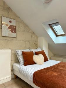 ein Schlafzimmer mit einem Bett mit orangefarbenen und weißen Kissen in der Unterkunft Terracotta - Quai de la Loire - Cozy in Tours + 7 Fotos