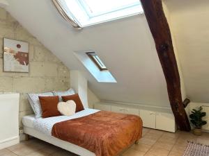 ein Schlafzimmer mit einem Bett und einem Dachfenster in der Unterkunft Terracotta - Quai de la Loire - Cozy in Tours