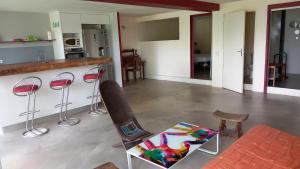 a living room with a counter and some chairs at T2 de 70m2 avec terrasse en rez de jardin in La Possession