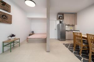 a room with a bed and a table and a kitchen at WineAfterSun Chaniotis Beach&Waves steps to beach in Hanioti