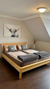 a bedroom with a large bed with a cow on the wall at Ferienwohnung Nr. 9 in Borkum +9 photos