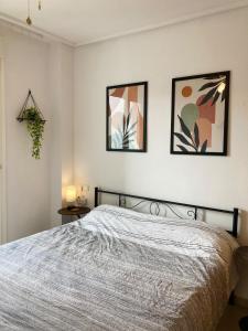 a bedroom with a bed with three pictures on the wall at Arty Apartment - La Torre Golf Resort in Torre-Pacheco