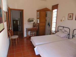 a bedroom with two beds and a table and chairs at VILLA DOLPHIN VOTSI in Votsi