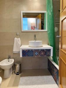 a bathroom with a sink and a toilet and a mirror at Arty Apartment - La Torre Golf Resort in Torre-Pacheco +17 photos