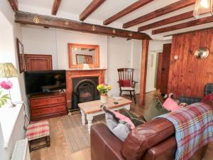 a living room with a couch and a fireplace at Chapel Cottage in Ebberston