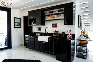 a kitchen with black cabinets and a sink at Fletcher American Manor Hotel & Resort in Prado