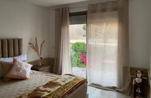 希迪布济德Appartement vue sur mer的一间带床和大窗户的卧室