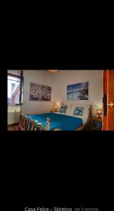 1 dormitorio con 1 cama azul y sillas en Appartamento LUCAS, en Stintino