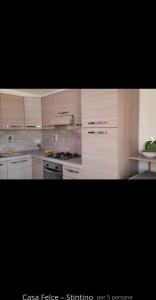 Una cocina blanca con gabinetes y electrodomésticos blancos. en Appartamento LUCAS, en Stintino 4 fotos más
