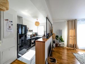 sala de estar con TV y cocina en Chic and comfortable aparts with parking, en Asnières-sur-Seine