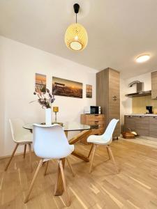 a dining room with a table and white chairs at Apartments Terra Solaris in Medulin