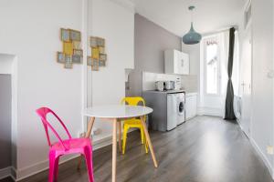 uma pequena cozinha com uma mesa e duas cadeiras em Appartement Lyon Villeurbanne - Enjoy in Lyon em Villeurbanne