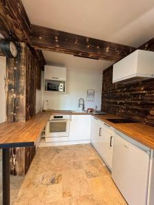 a kitchen with white cabinets and a brick wall at Chez Duch' in Mably