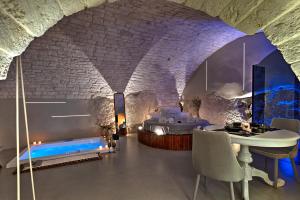 a room with a bed and a table and chairs at MALOLÙ luxurysuite in Ostuni