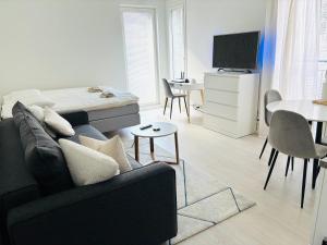 a living room with a couch and a bed and a table at Foliate Living Taimi in Jyväskylä