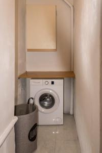 a laundry room with a washing machine and a trash can at Zen Beachfront Apartment in Kokkíni Khánion