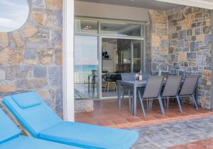 a patio with a table and chairs and a dining room at Zen Beachfront Apartment in Kokkíni Khánion