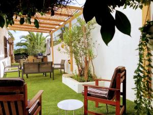a patio with chairs and a table on grass at Villa Tranquilla in Estepona