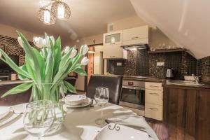 una cucina con tavolo e vaso di fiori di Apart-Styl Apartamenty Zakopane- Brzozowa, Centrum miasta a Zakopane
