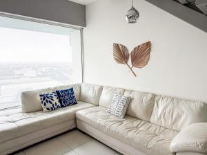 un divano bianco in un soggiorno con una farfalla sul muro di Penthouse w/ Terrace, Grill & City Views a Monterrey